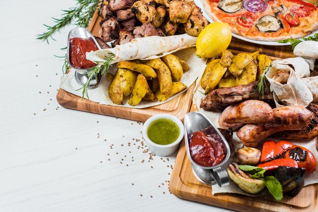 Big set of different dishes with meat vegetables pizza and spices flatlay on white background