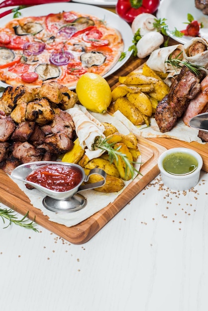 Big set of different dishes with meat vegetables pizza and spices flatlay on white background