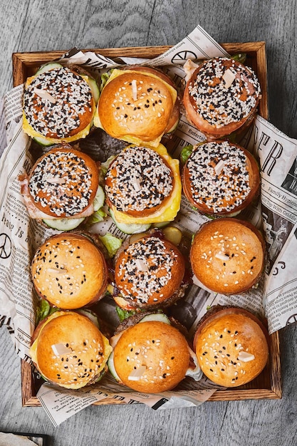 Большой набор из многих гамбургеров верхнего вида сырные бутерброды красиво расположены на подносе сет быстрого питания еда