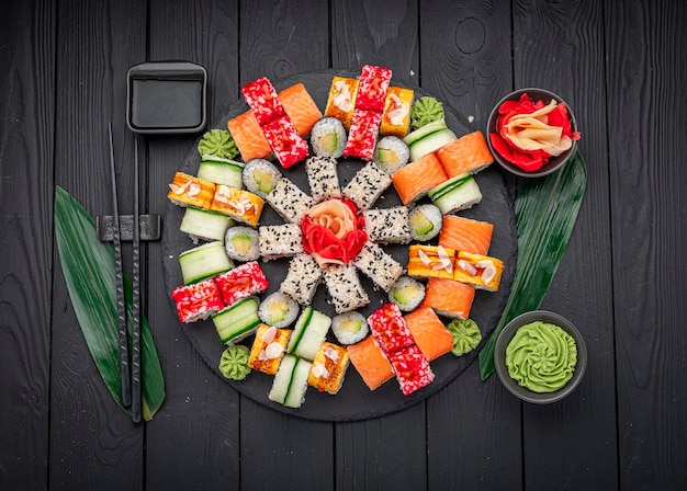 Фото Большой набор азиатских блюд суши и роллы на темном фоне