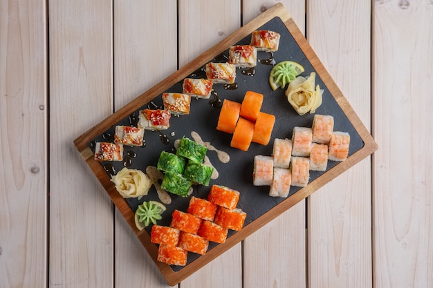 Big set of rolls served on stone plate