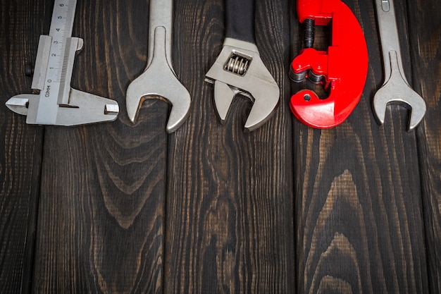 Big set of tools for a plumber on black wooden boards