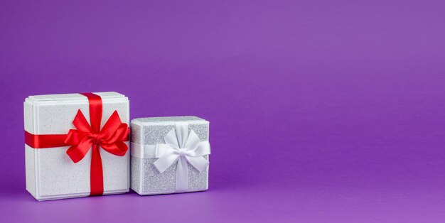 Big and small gift boxes on purple background