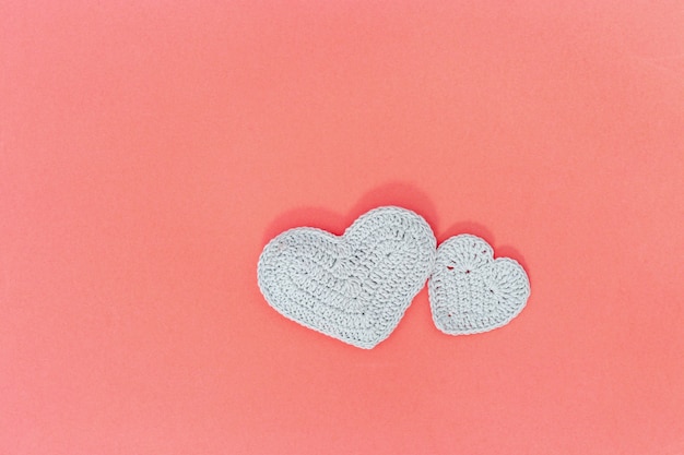 Big and small knitted hearts on paper background with copy space for text