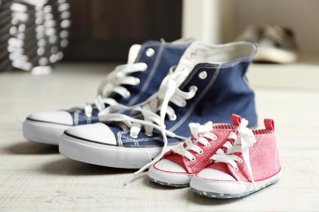 Big and small shoes on wooden floor