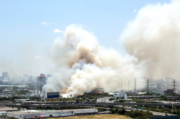 Grande fumo dal centro della città urbana con lo scape della città