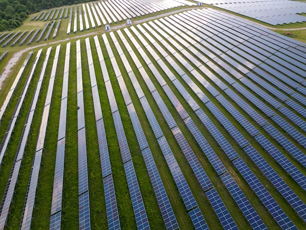 Big solar power station on a green meadow aerial view