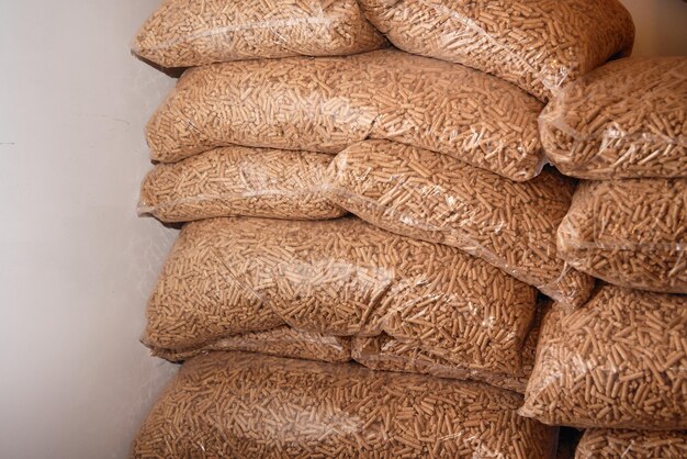 Big stacks of plastic bags full of wooden pellets sustainable\
future fuel