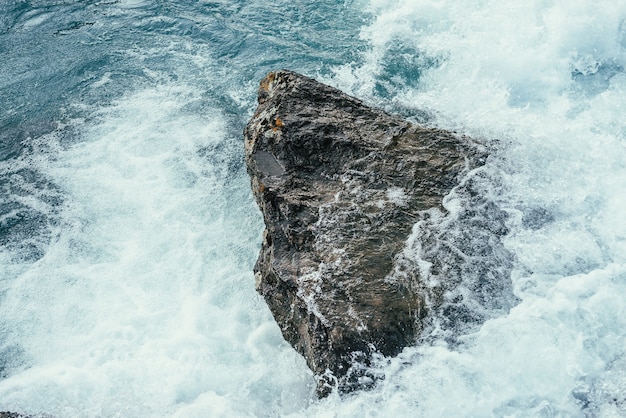 Big stone in azure water of mountain river