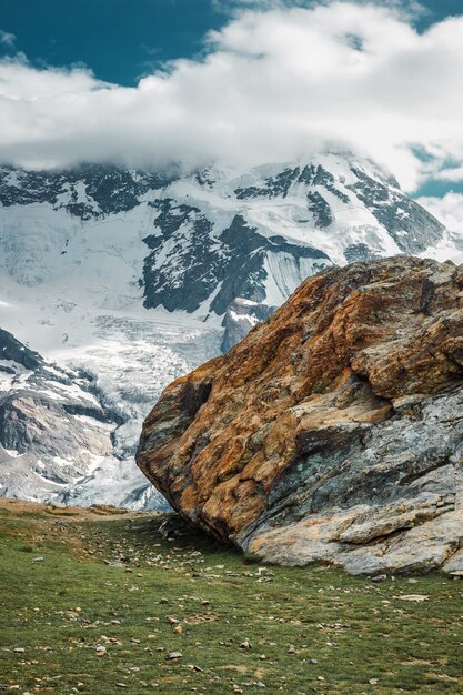 Big stone among snow mountains Zermatt Swiss Alps hiking in Switzerland panoramic landscape