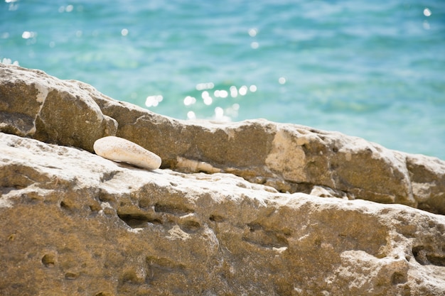 Большой камень на диком пляже. Концепция летних каникул. морской берег