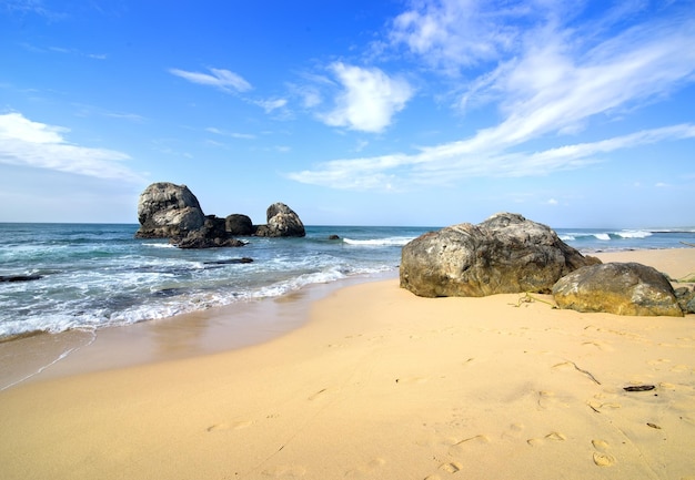 Big stones in the ocean and on a beach of Sri Lanka