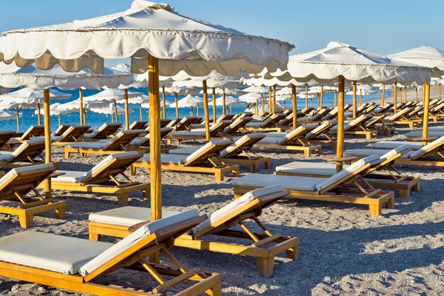 Big sunbeds and sunshades on the beach closeup