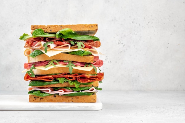 Photo big tasty sandwich with ham salami salad cheese and tomatoes