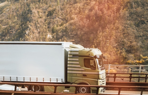 大きなトラックが海運会社の高速道路のコンセプトを移動しますヨーロッパのセミトラックが移動する風景