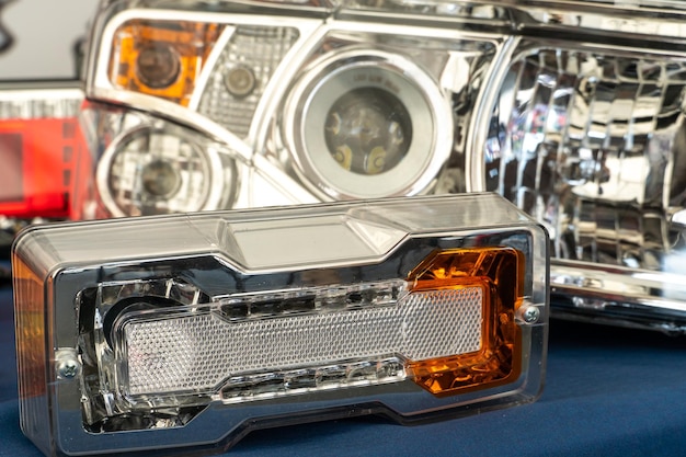 A big truck on the road Modern new halogen headlights on a truck Truck headlights Square red headlight and reflector on the back of the hood Car detail closeup