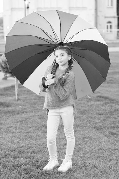 Under big umbrella Colorful accessory for cheerful mood Girl child long hair walking park with umbrella Stay positive and optimistic Colorful accessory positive influence Bright umbrella