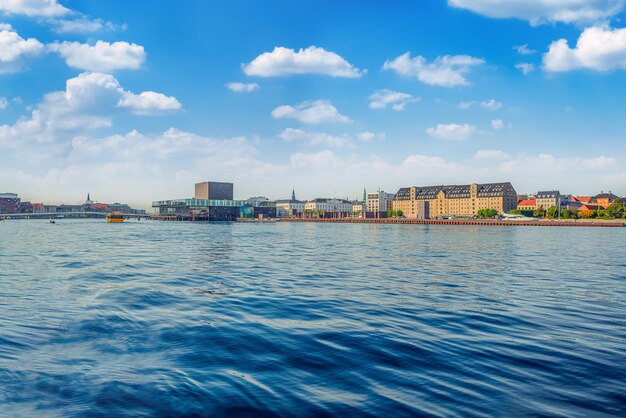 Big water canal with ships and boats royal danish playhouse and old buildings warehouses on the waterfront copenhagen denmark