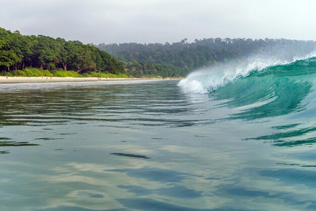 a big wave covers Radhanagar Beach At Andaman and Nicobar Island India view from the sea bursts of water at sea The spray of water droplets