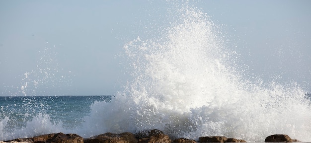 大きな波が海の泡で岸に衝突する