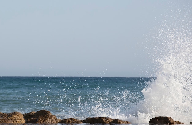 Big waves crash onto the shore with marine forma