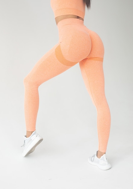 Photo a big woman booty in leggings on grey background.