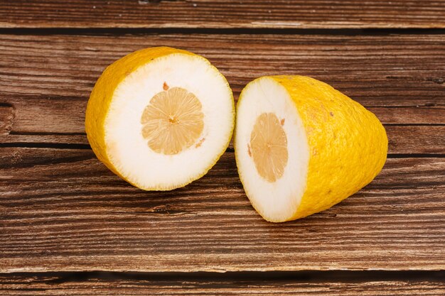 Большой желтый лимон на разделочной доске на деревянном столе