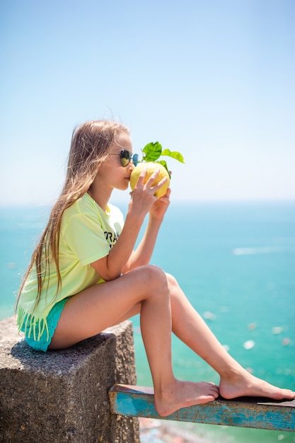 Big yellow lemon in hand in mediterranean sea and sky.