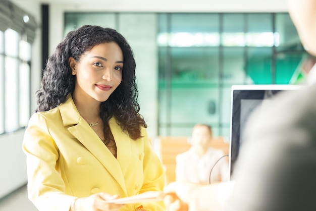 Bij de incheckbalie op de luchthaven overhandigt een passagier zijn documenten aan de manager via een balieticket