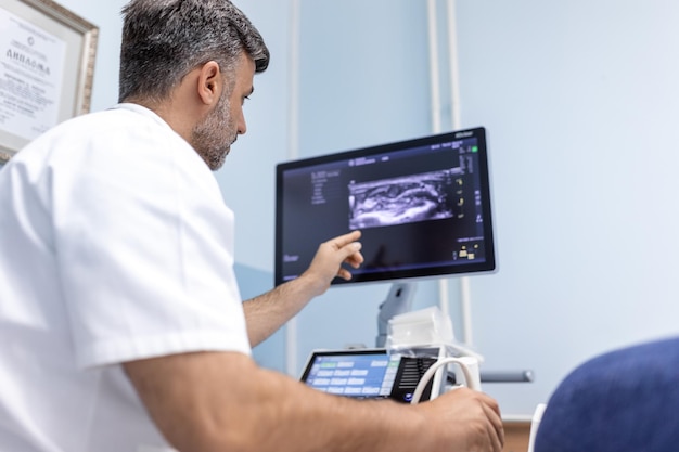 Bij de medische kliniek doet een blanke mannelijke arts de doppler-echografietestevaluatie van slagaders en aders bij een vrouwelijke patiënt