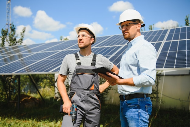 Bij de zonnepanelen laat de medewerker het werkplan aan de baas zien