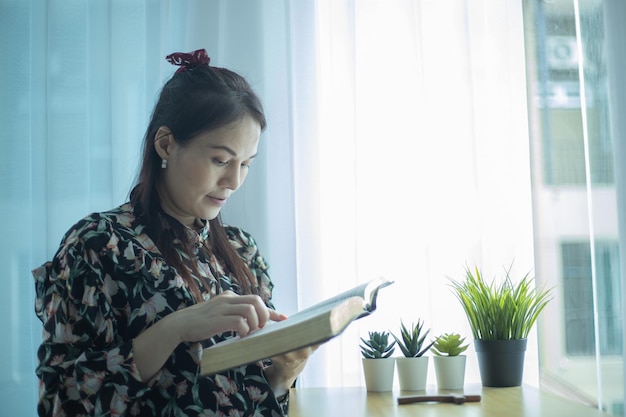 Bijbelstudieconcept Aziatische vrouw leest thuis de bijbel