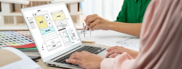 Foto bijgesneden afbeelding van het interieurontwerperteam bespreekt de materiaalkleur terwijl de laptop website-draadframe-ontwerpen voor mobiele app en website weergeeft creatief ontwerp en bedrijfsconcept bont