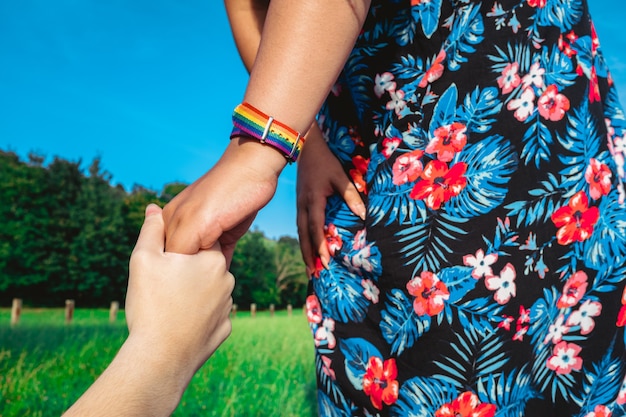 Bijgesneden afbeelding van twee jonge Aziatische vrouwen met LGBT-trots, een homoseksueel lesbisch paar houdt handen vast.