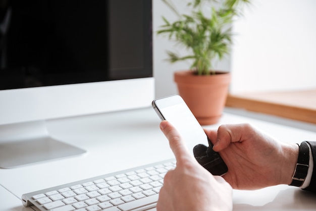 Bijgesneden afbeelding van zakenman chatten via de telefoon.