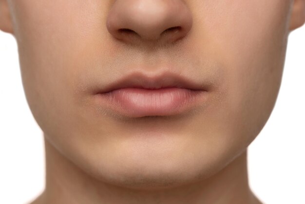 Bijgesneden close-up beeld van mannelijke lippen perfecte huid geïsoleerd over witte studio backgorund