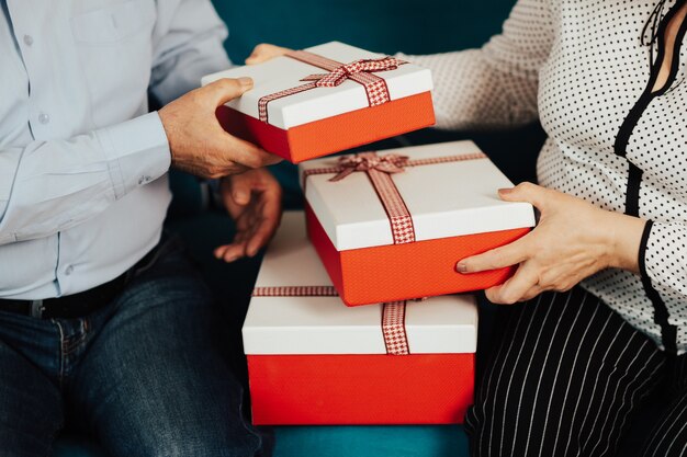 Bijgesneden close-up foto van een handen van senior paar houdt een geschenkdozen.