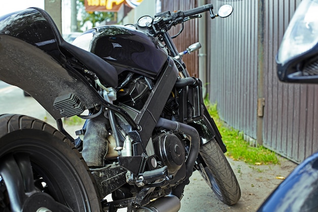 Bijgesneden close-up shot van mooie en op maat gemaakte motorfiets geparkeerd op straat
