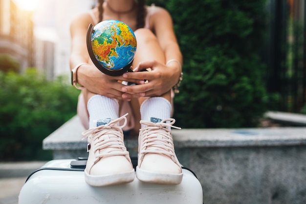 Bijgesneden foto Mooie jonge vrouw houdt een kleine wereldbol vast