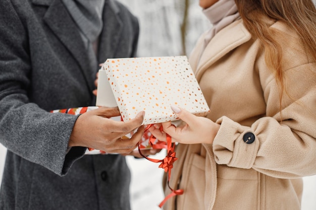 Bijgesneden foto van een geschenkdoos in handen van zwarte man en blanke vrouw