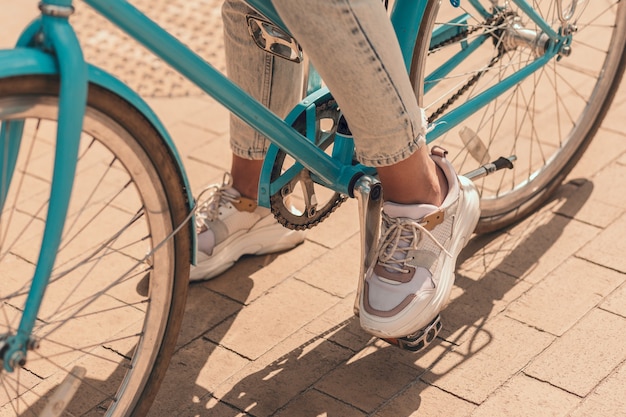 Bijgesneden foto van een vrouw die voet op het fietspedaal zet