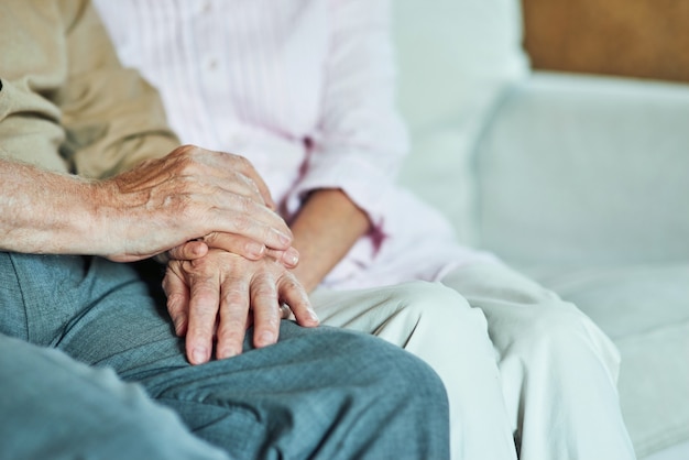 Bijgesneden foto van oudere man die de handen van zijn vrouw vasthoudt