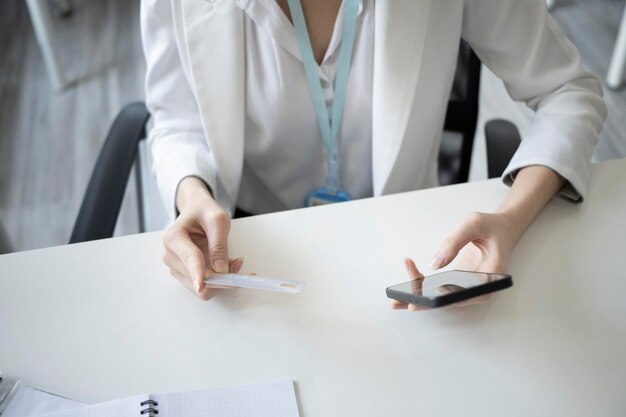 Bijgesneden geschoten zakenvrouw met creditcard en online bankieren op haar smartphone.