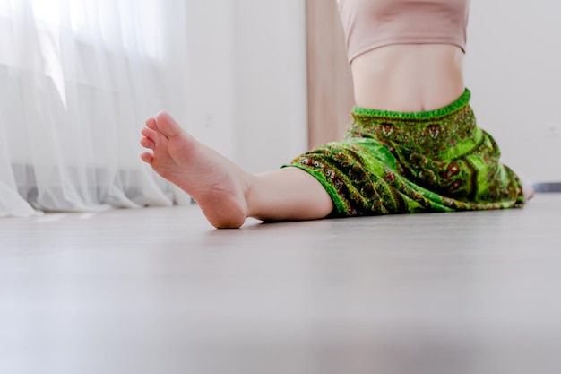 Bijgesneden jonge vrouw doet been split stretch yoga pose