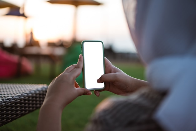 Bijgesneden opname van de handen van de vrouw met een smartphone met een leeg kopieerruimtescherm