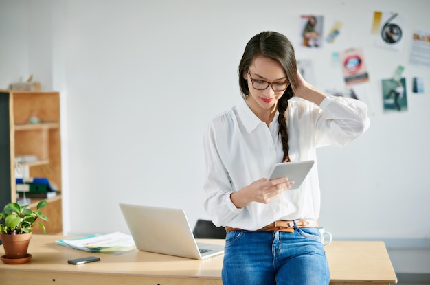 Bijgesneden opname van een aantrekkelijke jonge zakenvrouw die een digitale tablet op kantoor gebruikt