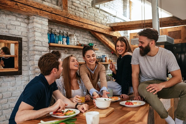 Bijgesneden opname van een groep vrienden die ontbijten in de keuken