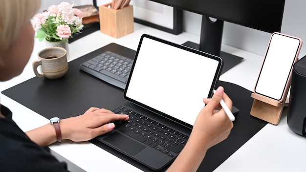 Bijgesneden opname van een jonge vrouw die een styluspen vasthoudt en op een computertablet werkt op een creatieve werkplek.