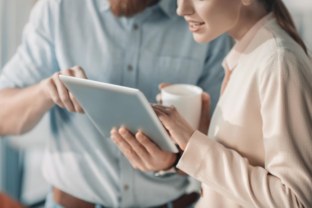 Bijgesneden opname van jonge zakenman en zakenvrouw met behulp van digitale tablet