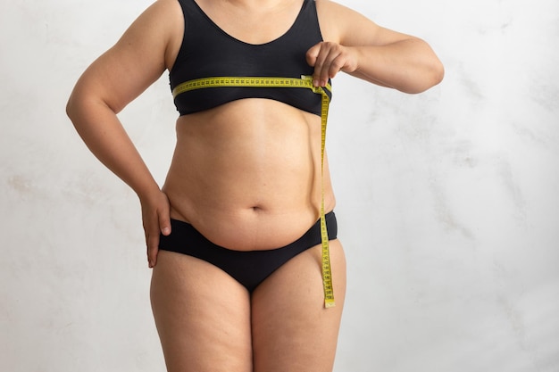 Bijgesneden overgewicht dikke vet vrouw in zwarte lingerie maatregel borst door tape roulette Afslanken gewichtsverlies dieet
